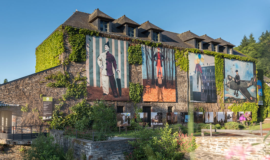 Eine Hausfassade in La Gacilly ist mit Fotos der Open-Air-Fotoausstellung verziert