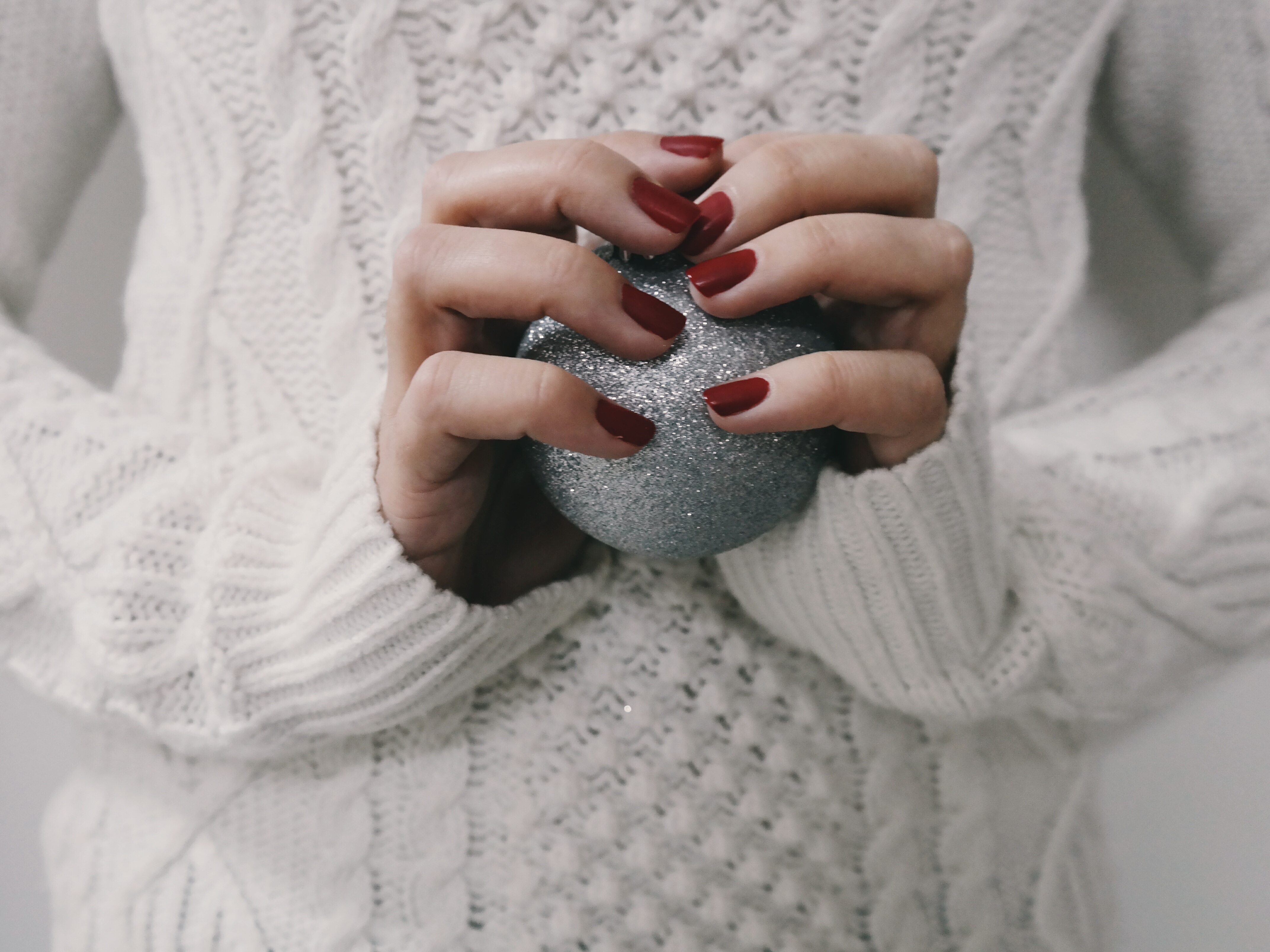 Mains avec du vernis à ongles rouge festif