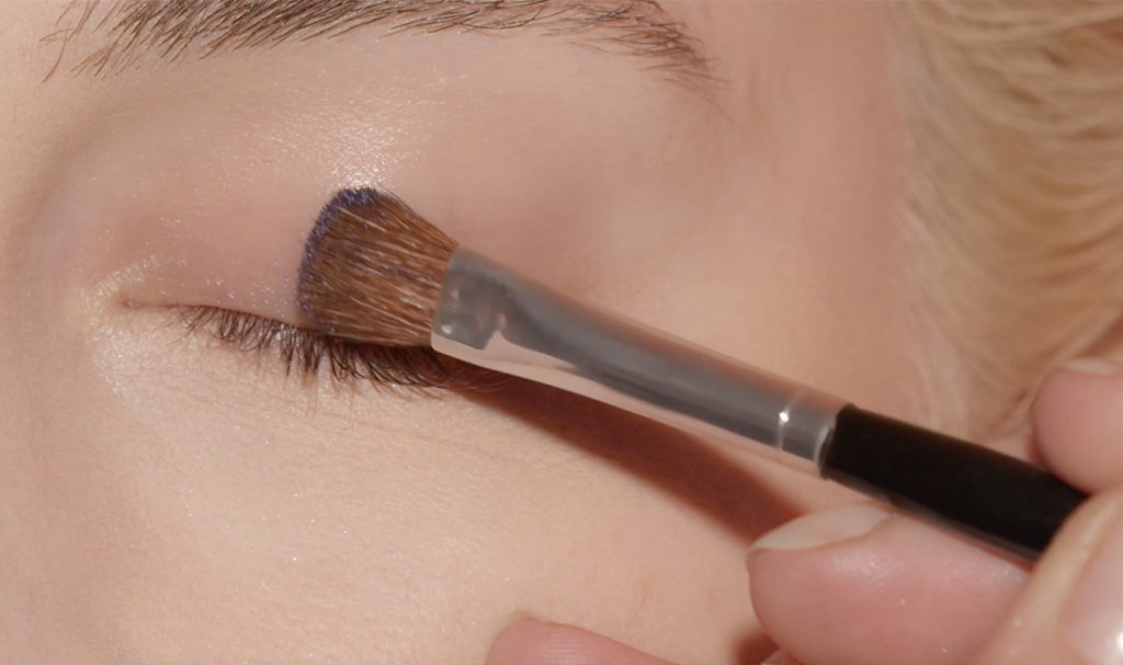 femme utilisant le pinceau de maquillage sur sa paupière