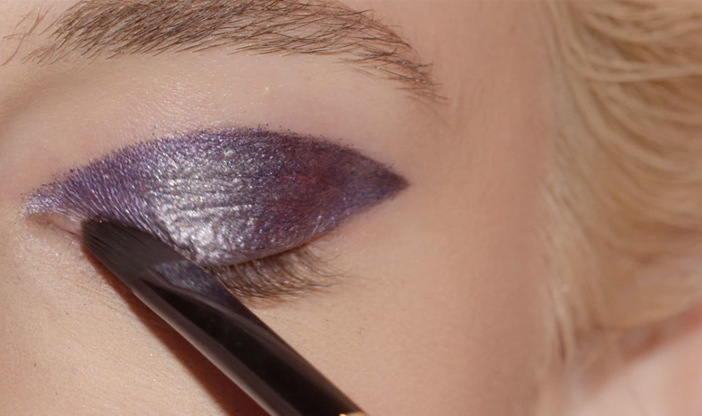 femme utilisant le pinceau de maquillage sur sa paupière