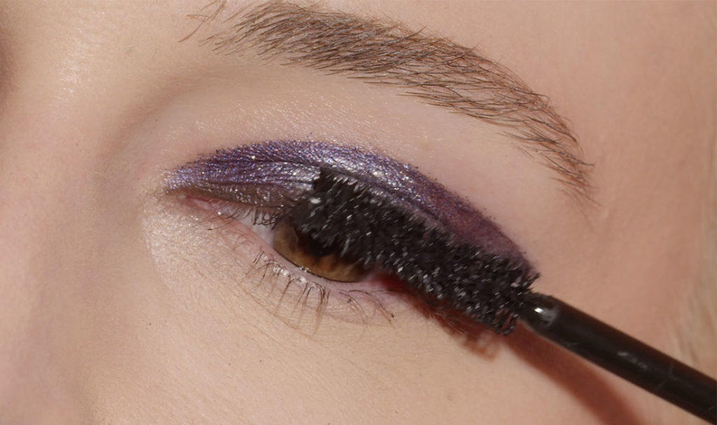 femme utilisant le pinceau de maquillage sur sa paupière