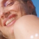 femme européenne souriante sous le soleil et le ciel bleu